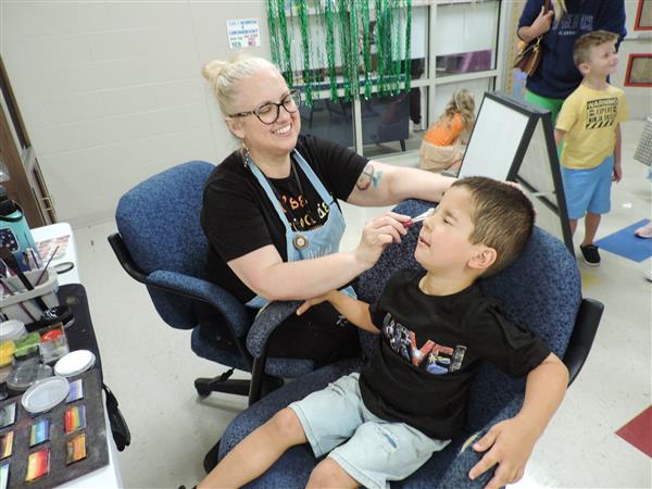 teacher painting a child's face